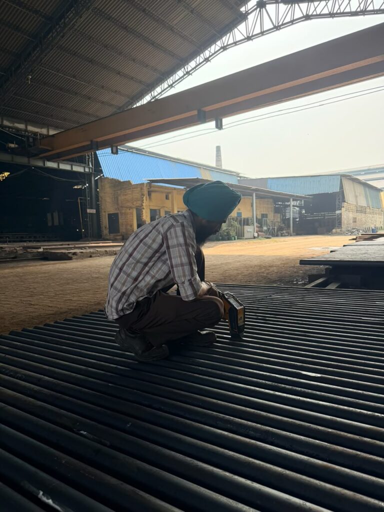 Handheld XRF grade check on a bed of round bars under the shed